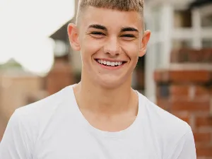 Image of a teenager in a white t shirt smiling
