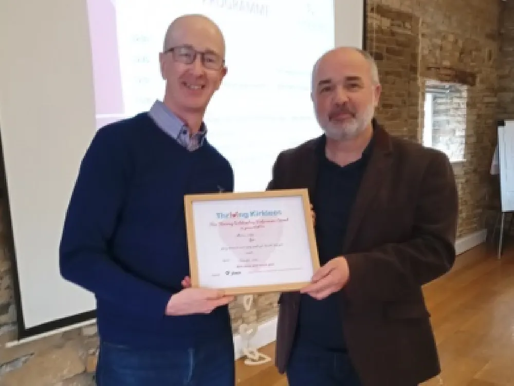 Photo of a volunteer receiving an award from our Chair of Trustees