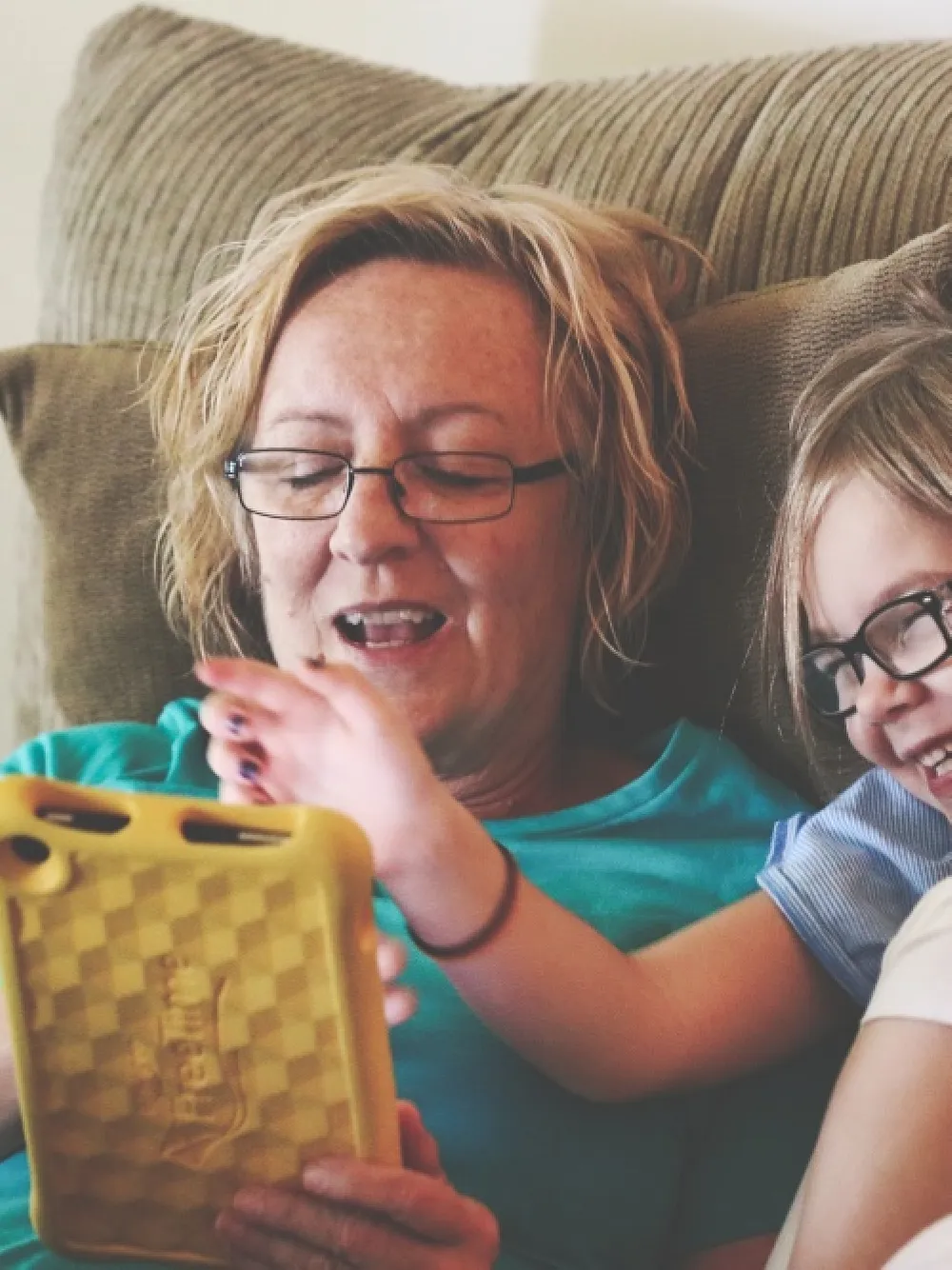 Photo of young girl and older woman using a tablet device. 