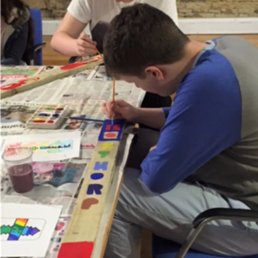 Photo of young boy painting at a table