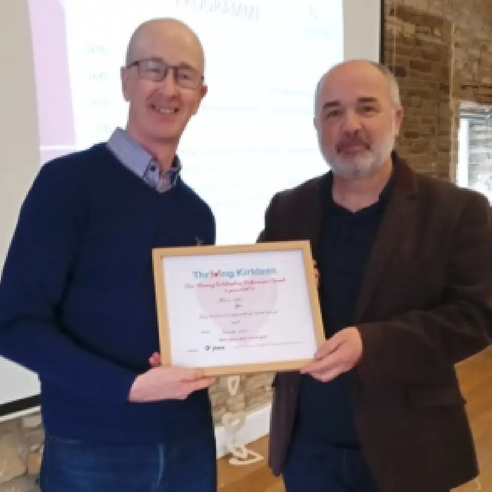 Photo of a volunteer receiving an award from our Chair of Trustees