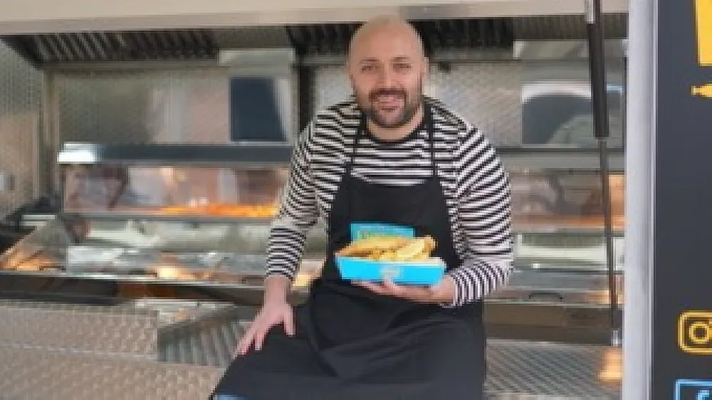 Photo of a man serving fish and chips