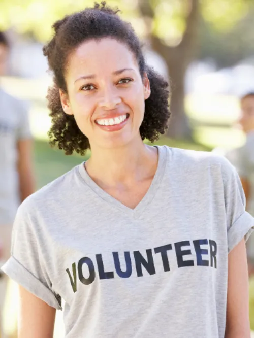 photo of a woman smiling and wearing a grey volunteer T shirt