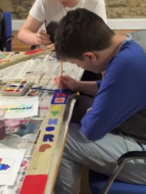 Photo of young boy painting at a table