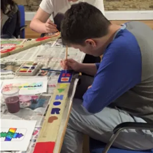 Photo of young boy painting at a table