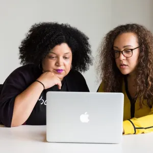 Two black women working together on a laptop