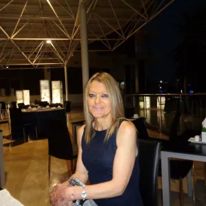 Photo of a sitting woman in a large room.