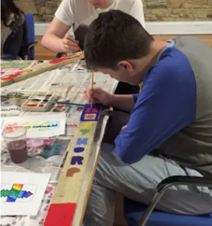 Photo of young boy painting at a table