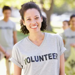 photo of a woman smiling and wearing a grey volunteer T shirt